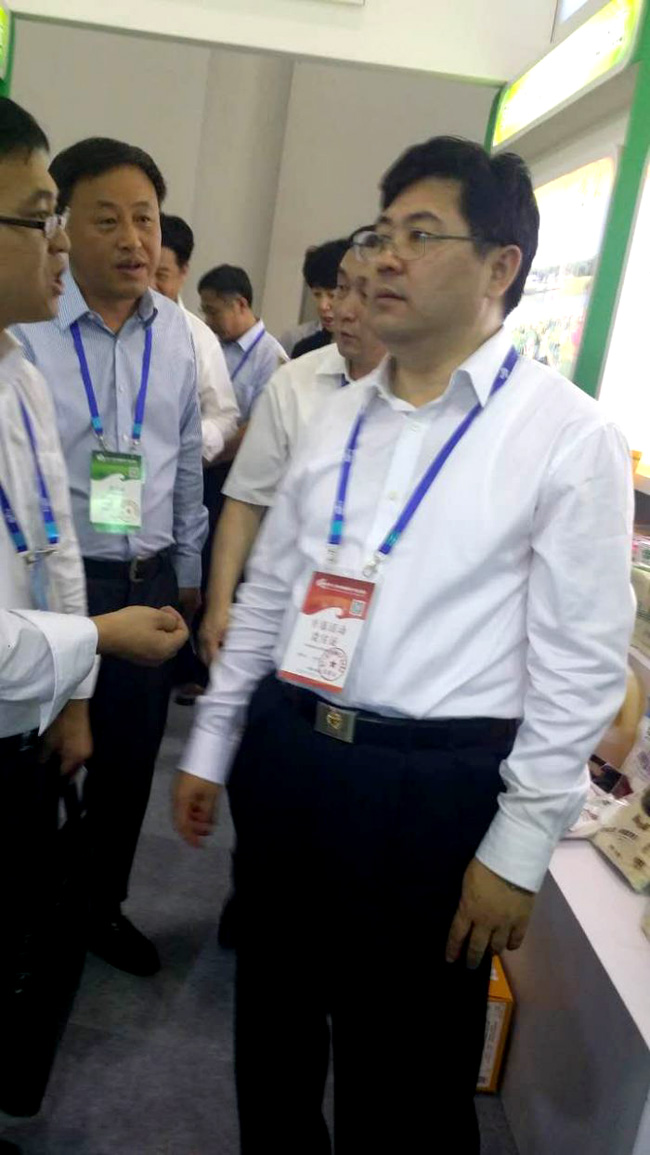 北显集团销售部杨小伟经理向吉林省隋忠诚副省长(右一)介绍参展情况